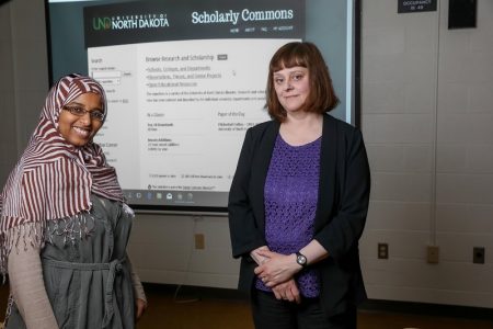 Zeineb Youssif (left) and Stephanie Walker (Dean of Library) with an image of the Scholarly Commons introduction page projected behind. Yousif recently was named as one of Library Journal’s “Movers & Shakers” for 2021. UND photo.