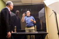 UND Education Professor Marcus Weaver-Hightower demonstrates his innovative "lightboard" teaching tool to UND President Mark Kennedy recently. Photo by Richard Larson.