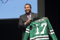 Veteran ABC News correspondent John Quinones proudly holds a UND hockey jersey given to him Monday night by  Delta Gamma after his speak at the Chester Fritz Auditorium Monday. Photo by Jackie Lorentz.