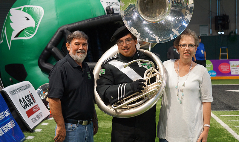 UND Pride of the North Marching Band sousaphonist Seth Skjervheim stands with his dad, Don, and mom, Kathy, recently during a UND Fighting Hawks fooball game. Seth recently donated bone marrow to an anonymous man stricken with leukemia.  He then returned to UND to perform with the band only days after the donation. Image courtesy of the Pride of the North Marching Band.