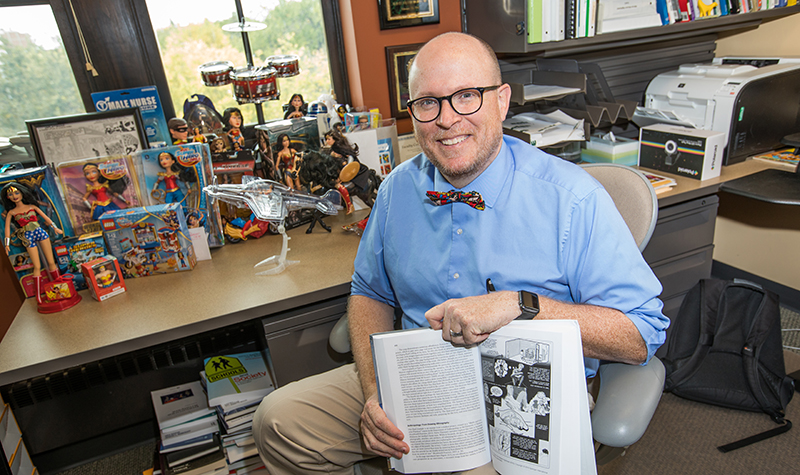 In addition to researching comics and graphic novels, UND Education Professor Marcus Weaver-Hightower, who describes himself as a decent artist, also writes them. Photo by Jackie Lorentz.