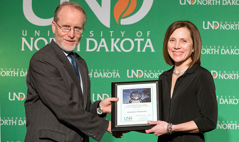 University System Chancellor Mark Hagerott presents the UND Foundation/B.C. Gamble Faculty Award for Excellence in Teaching, Research or Creative Activity, and Service to
Daphne Pedersen (Sociology) at the 2018 Founders Day celebration on Feb. 22. Photo by Jackie Lorentz/UND Today.