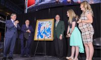 From the left, Gov. Doug Burgum, State Historical Society Director Bill Peterson, Secretary of State Al Jager, Monique Lamoureux-Morando and Jocelyne Lamoureux-Davidson at Ralph Engelstad Arena presenting the Rough Rider Award and unveiling the painting for the North Dakota Hall of Fame.