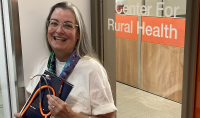 Dr. Kay Miller Temple, a physician/journalist who is a web writer for the Rural Health Information hub, holds a stethoscope as well as a notebook and pen, the tools of her two trades. Photo by Tom Dennis/UND Today.
