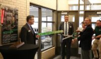 Jim Klosterman, standing next to his wife, Jan, gets ready to cut the ribbon being held by UND President Andrew Armacost (left) and Robert Kraus, dean of the Odegard School of Aerospace Sciences,  to dedicate the new Annette Klosterman Aviation Safety and Data Analytics Lab. The new lab in Odegard Hall is named in honor of the Klosterman's daughter, Annette. Photo by Tom Dennis/UND Today.