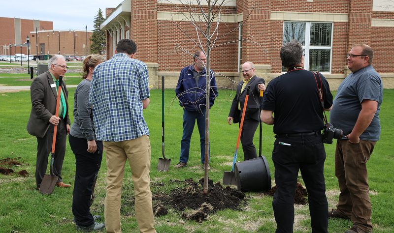 Jed Shivers (left), vice president for finance and operations at UND, and others survey their handiwork after planting a tree as part of UND's Arbor Day celebration on May 11, 2022. Photo by Tom Dennis/UND Today.