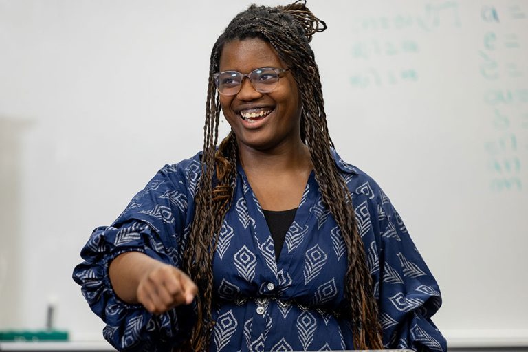Ketina Francois stands and smiles in blue dress