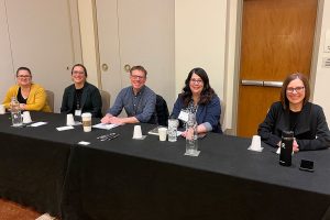 Five people sit at table.