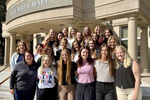 Group of graduate students stand on steps of Columbia Hall