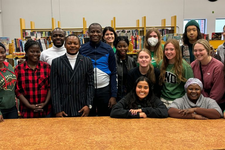 group of people standing in front of shelves with books