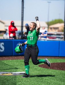 CSD student-athlete Taya Hopfaug holds arm up in celebration on the softball field
