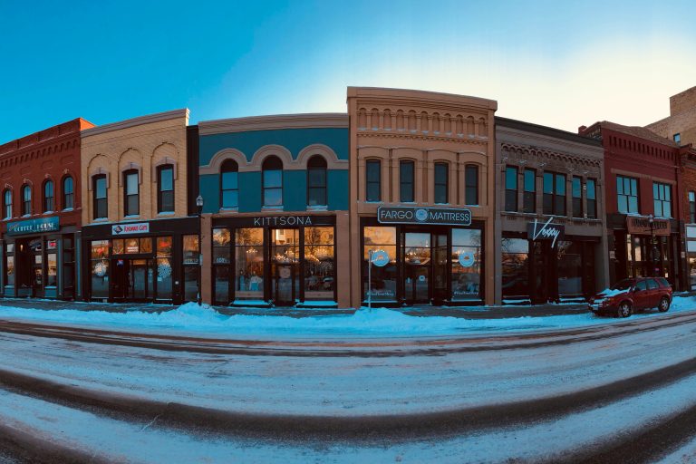 picture of a main street in a rural town with several businesses side by side.