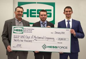 Brent Lohnes stands with two mechanical engineering students holding large check.