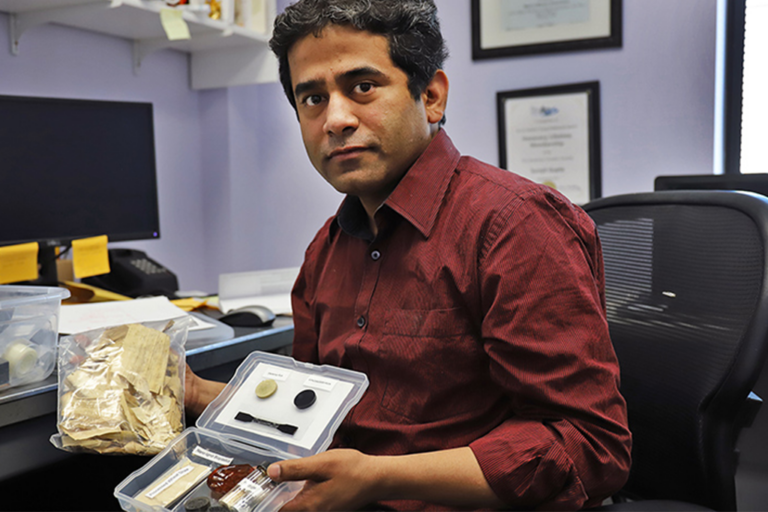 UND professor Surojit Gupta holds samples of raw materials used in the Materials Science Lab.