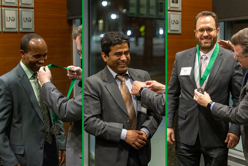 Three CEM faculty receive medals in front of audience at ceremony