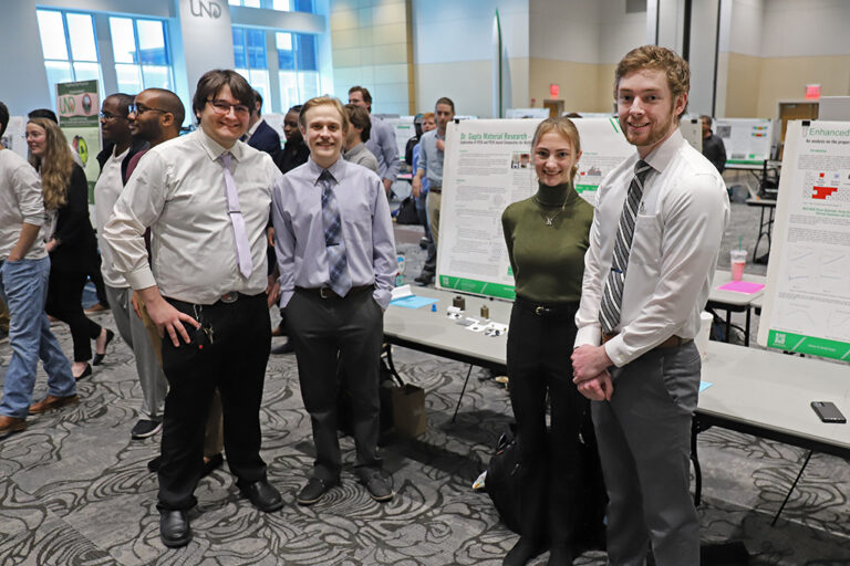 Students standing in front of design poster at expo