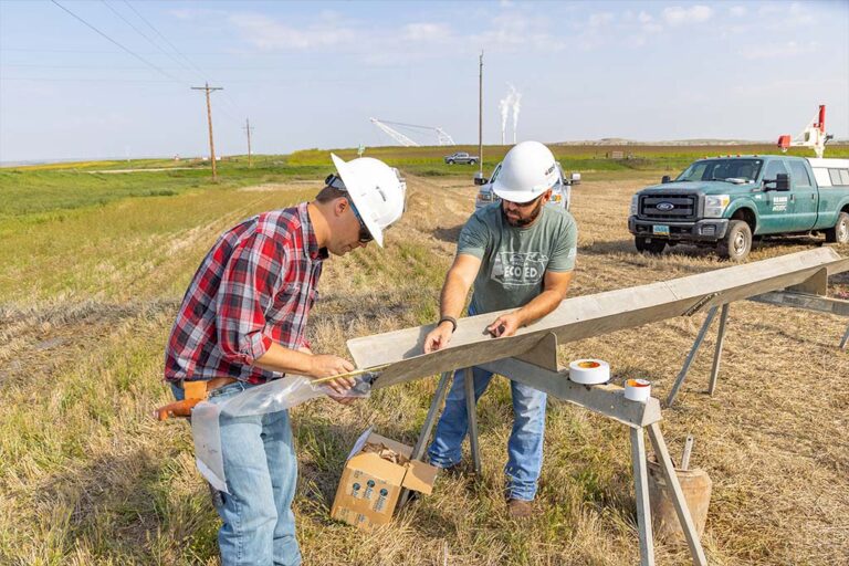 Two men work measure core sample outdoors