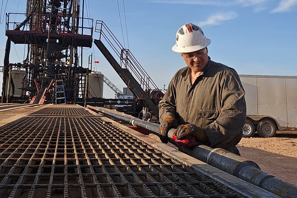A person wearing a hard hat works on an oil well in Dickinson, North Dakota.