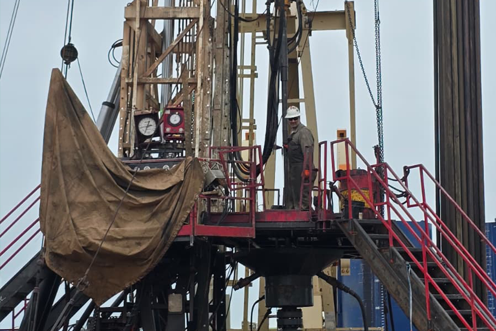 A person stands on top of an oil rig in Dickinson, North Dakota.