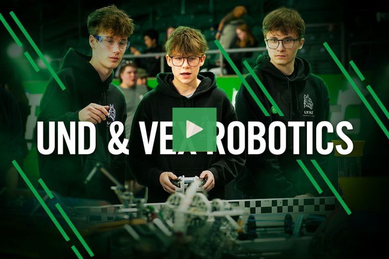 A video thumbnail showing students at a robotics competition with their robot in action. Text reads: "UND & VEX Robotics".