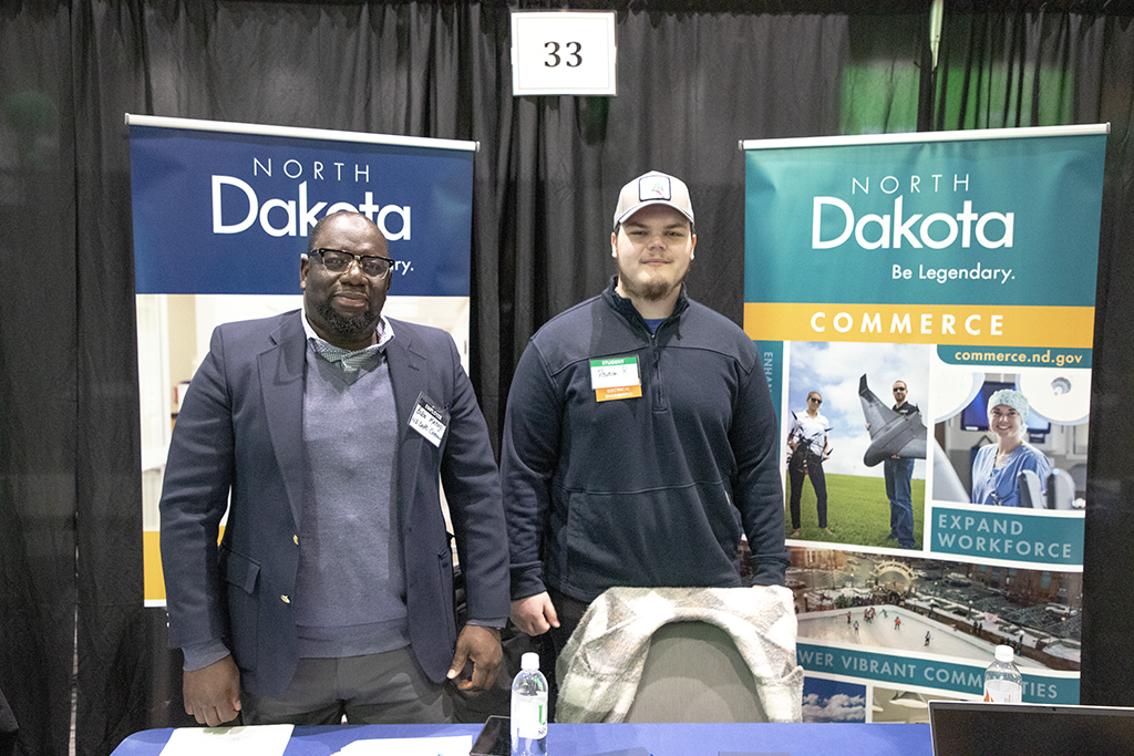 A talent coordinator and a student stand next to each other at a North Dakota Commerce booth.