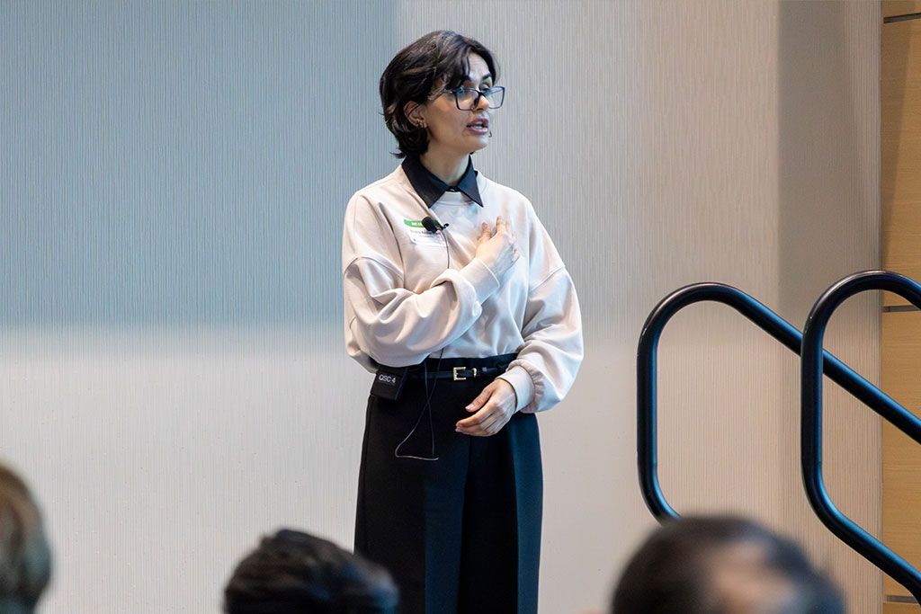 A student presents on stage to a group of people.