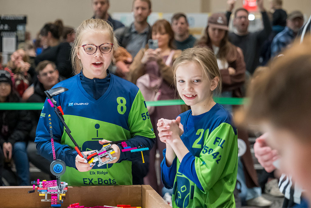Two girls smile as they compete in a LEGO robotics competition at the University of North Dakota.
