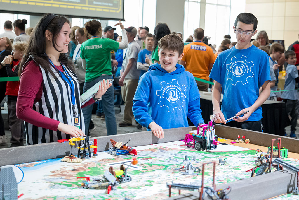 A college student volunteers as a referee during a robotics competition at the University of North Dakota.