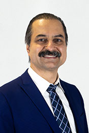A professional headshot of Kouhyar Tavakolian.