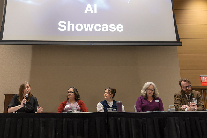 Five people sit at a panel inside of the University of North Dakota Memorial Union ballroom.