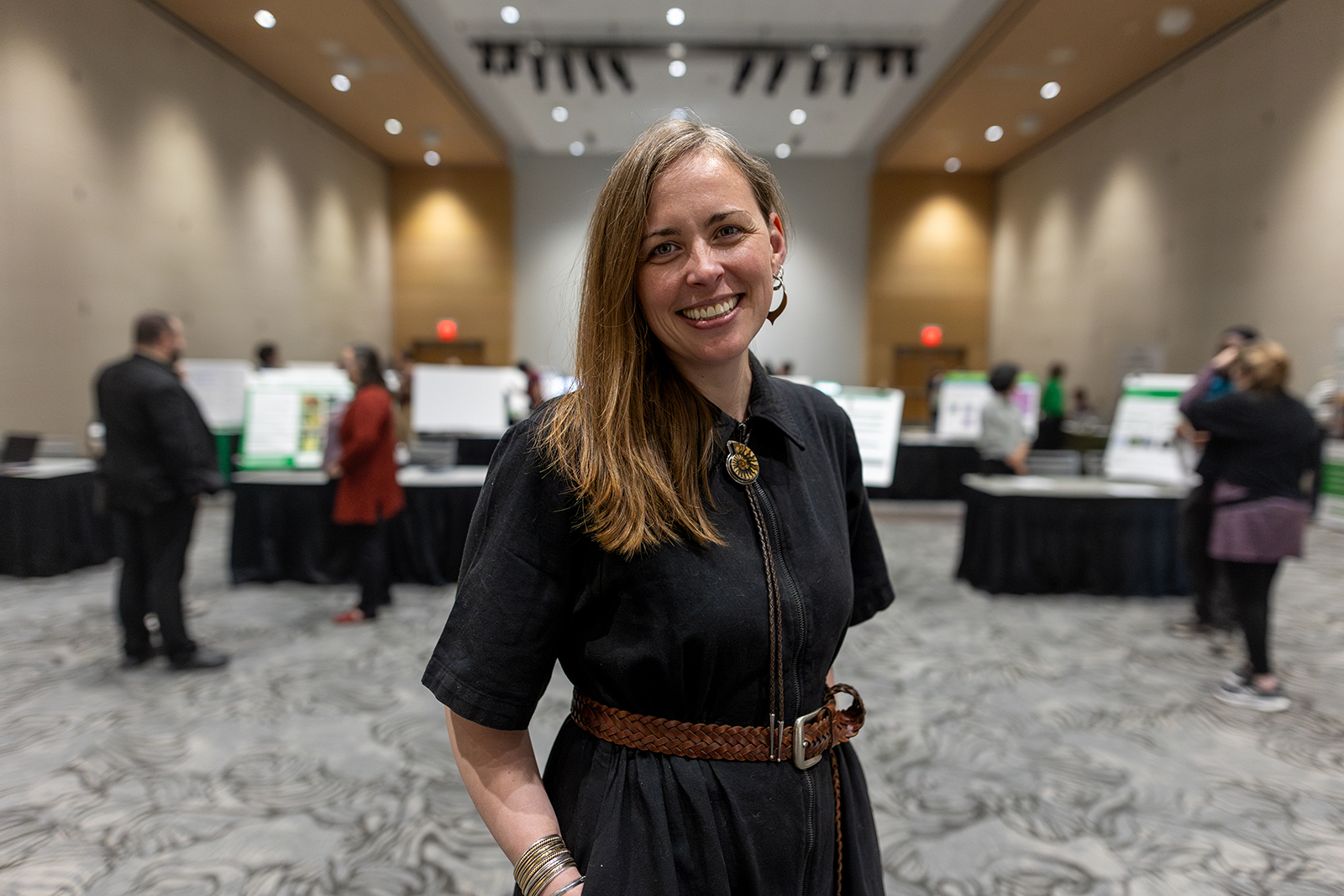A person smiles at the camera for a photo inside of the University of North Dakota Memorial Union ballrooms.