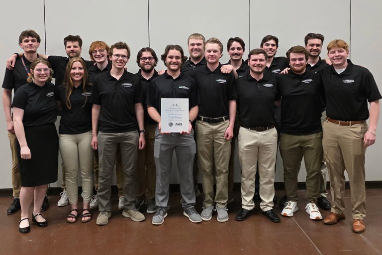 A group of University of North Dakota civil engineering students stands for a group photo with a first-place prize.
