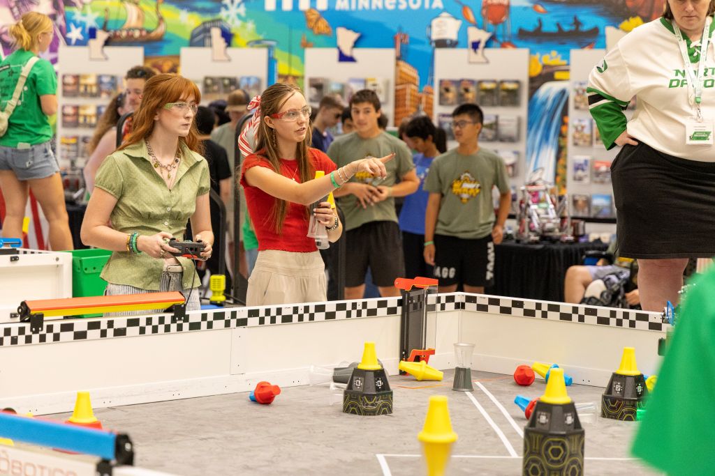 Two students work together on the competition floor of a robotics tournament hosted by the University of North Dakota at the Mall of America.