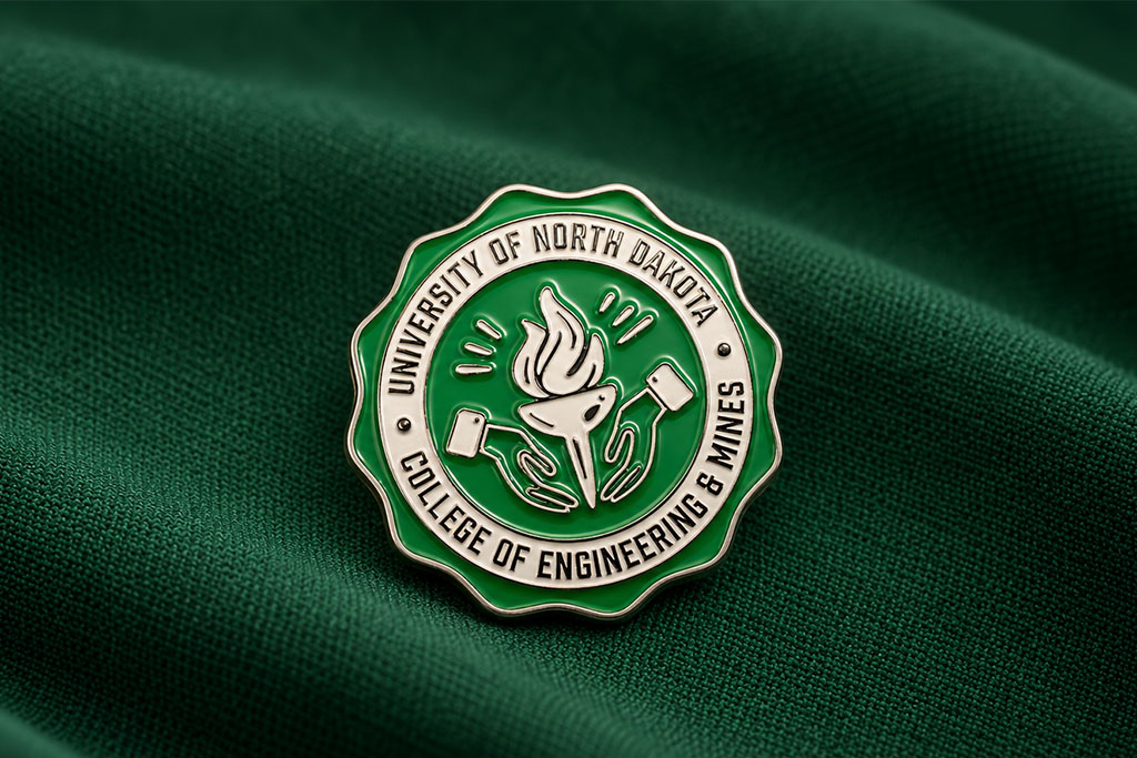 A ceremonial pin photographed against a fabric backdrop features a lit torch passing hands.
