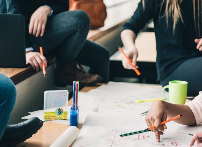 Group of people sitting around a table and working on a project together