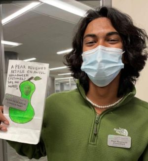 a person holding up a drawing of a pear