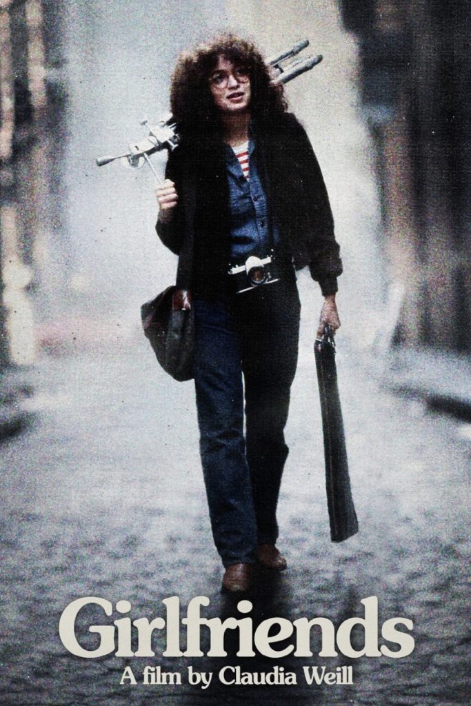 Movie poster for Girlfriends depicting the heroine carrying photography equipment down a city street