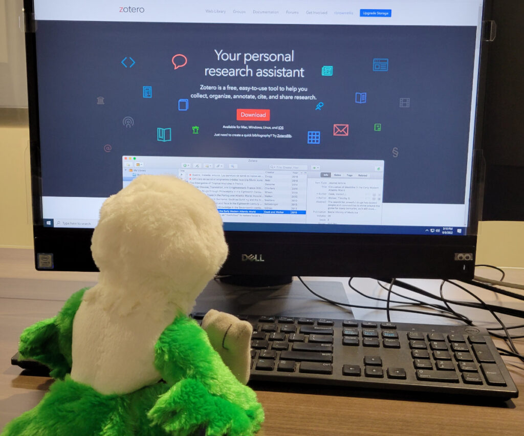 a plush bird sitting in front of a computer showing the zotero login screen