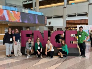 Faculty, staff, and students pose infront of large FNCE letters.