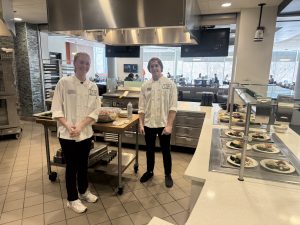 Two students in a professional kitchen.
