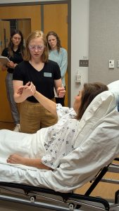 A N&D student practices a simulation with a live patient in an exam room.
