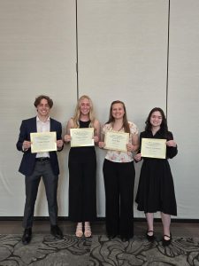 Four students hold certificates recieved at the SAND banquet