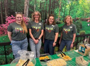 Autum and preceptors with Valley Senior Living stand behind a table serving food.