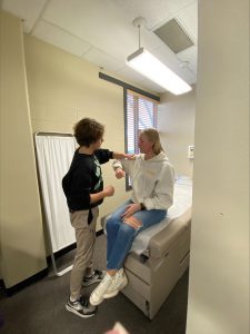 A N&D student practices a simulation with a live patient in an exam room.