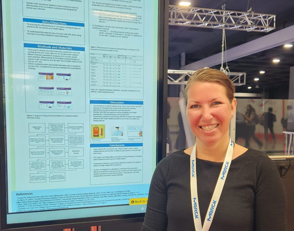 Dr. Renee Colsch stands in front of a vertical digital sign displaying her research work