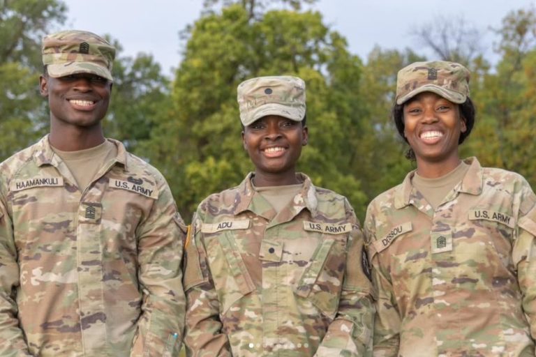 Three ROTC cadets pose for a picture in camoflage fatigues. Priscilla Adu is in the center.