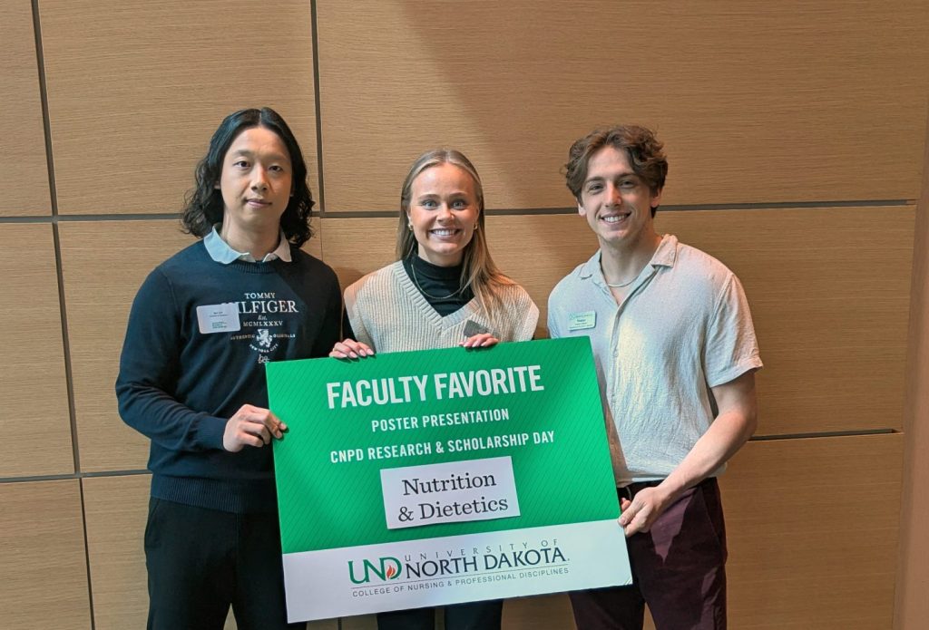 Three N&D students hold a faculty favorite sign.