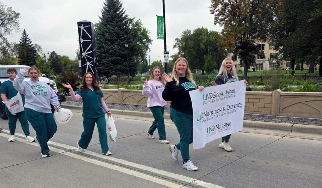 Students wave to the camera as they march in the parade