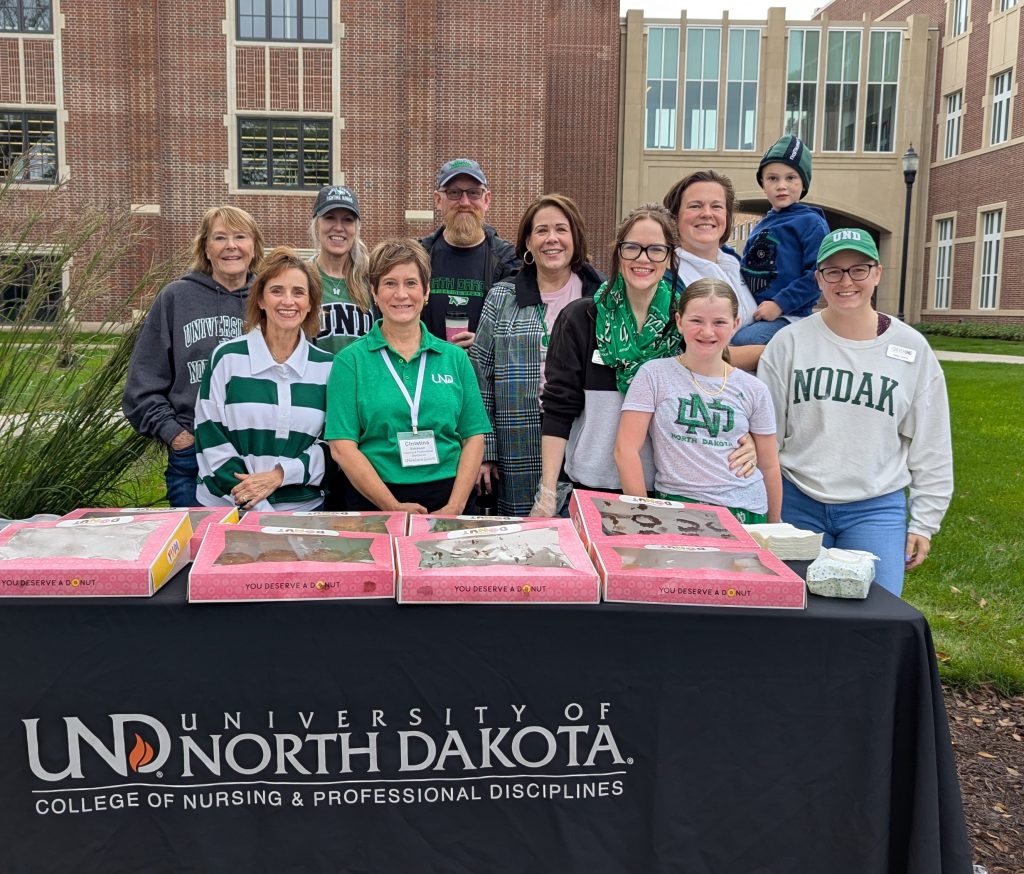 CNPD staff stand behind a table with donuts in pink boxes.