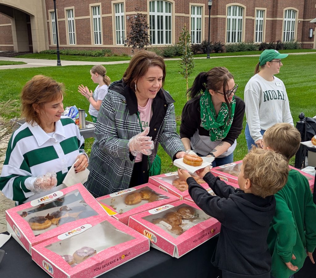Dean Shogren hands a donut to a parade goer